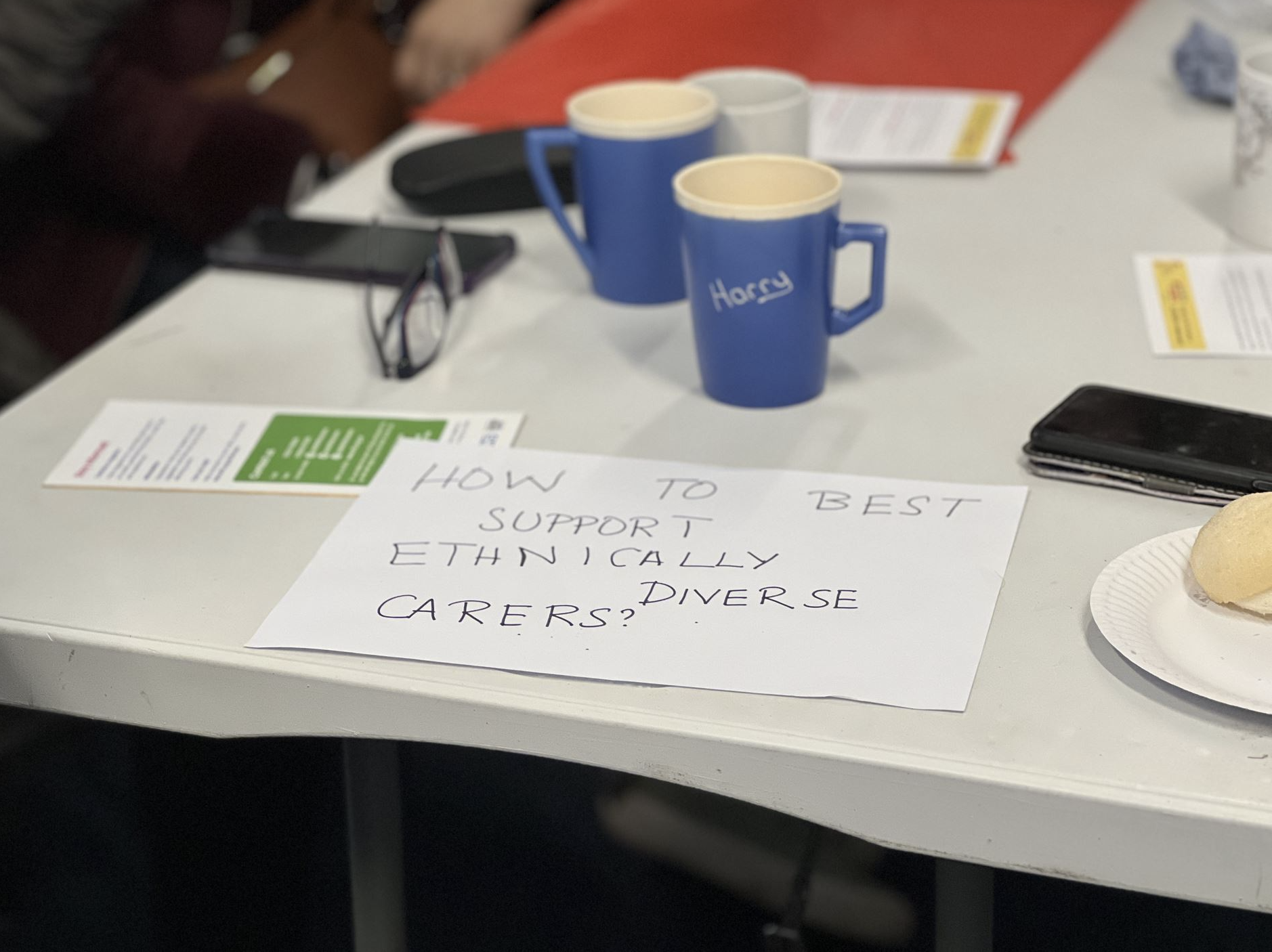 A white table topped with a paper sheet that reads 'How to best support ethnically diverse carers?'